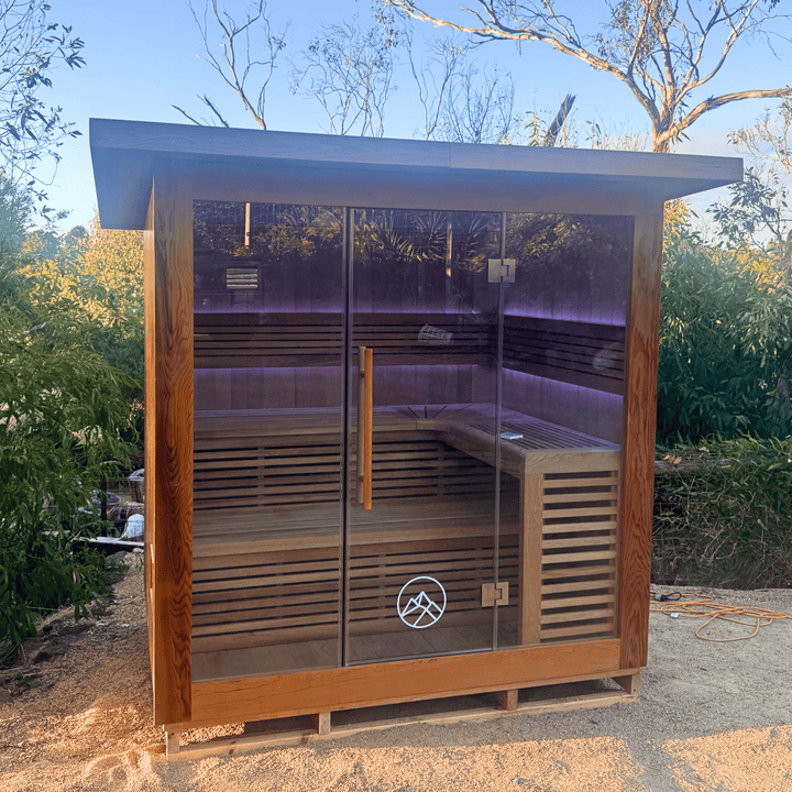 the macedon sauna by peak sauna and ice installed outdoors surrounded by trees